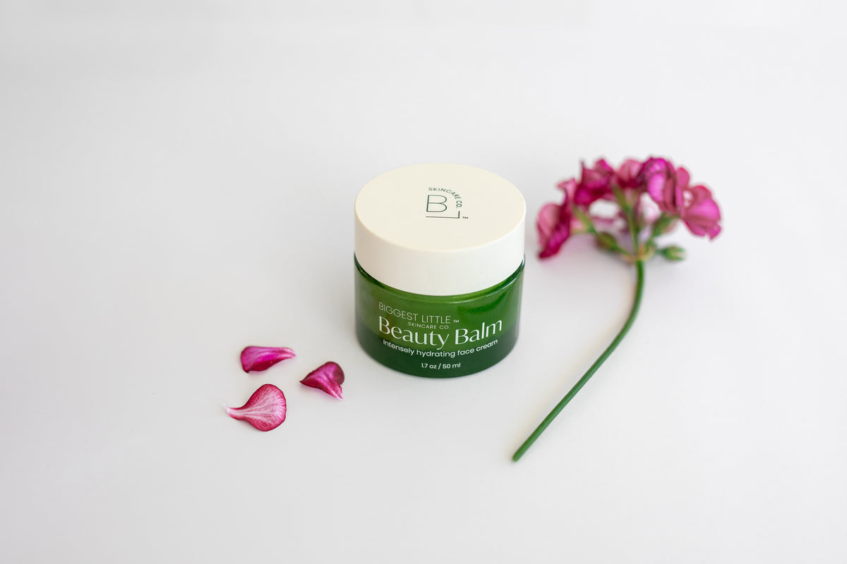 Jar of Beauty Bal surrounded by geranium flowers