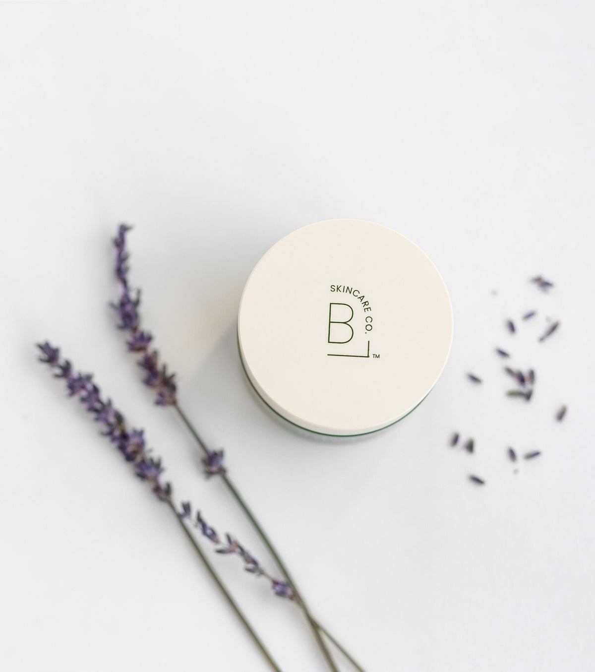 Jar of Biggest Little Skincare Beauty Balm surrounded by lavender seeds